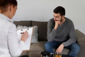 Man talking to therapist, seeking help for mental health issues.