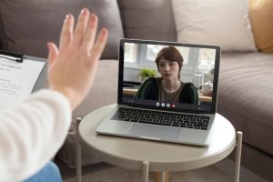 A therapist and client connecting via virtual therapy, providing mental health support.